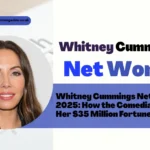 Whitney Cummings on stage, holding a microphone and smiling, representing Whitney Cummings Net Worth and her successful comedy career.