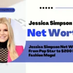 Jessica Simpson Net Worth featured image showing the blonde entrepreneur smiling in a black patterned top and pink blazer, highlighting her journey from pop star to $200 million fashion empire builder.