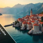 Kotora Melnkalne aerial view showing Kotor Old Town red rooftops, fortress walls, and Bay of Kotor with mountains in Montenegro