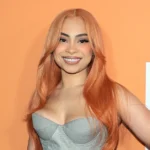 Ice Spice influencer performing on stage at concert with orange curly hair and microphone showing her rapper and social media star status