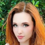 Who is Amouranth — Kaitlyn Siragusa streaming at her setup with purple and green studio lighting