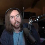 Who is Asmongold streaming setup showing gamer Zack Hoyt playing games with Twitch chat visible on screen