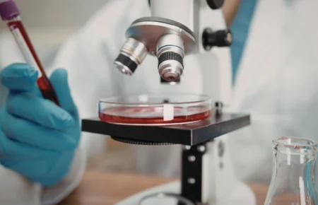 A clinician performing a blood draw at a blood analysis laboratory for preventive healthcare screening