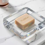 Décor Walther Cut Crystal Soap Dish in crystal clear glass displayed on a white bathroom vanity countertop.