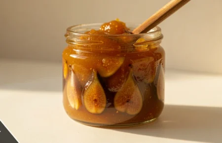 Jar of mustarda with golden-brown preserve and spoon, traditional Croatian mustarda condiment made with mustard seeds